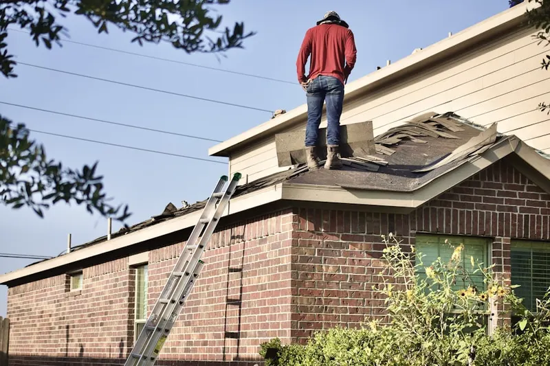Professional roofer working on a residential roof in Sheffield Manor